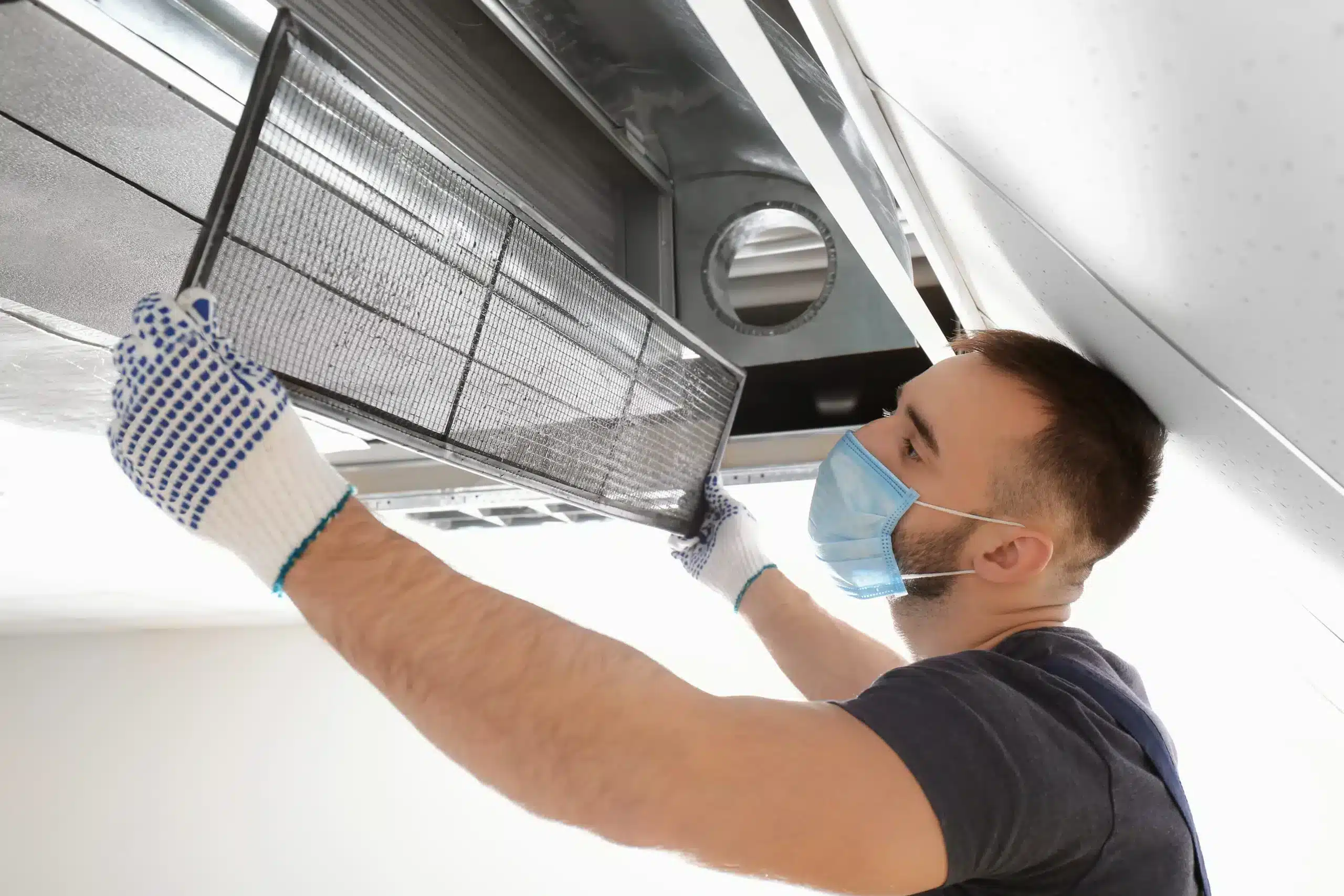 Technician cleaning air duct interior